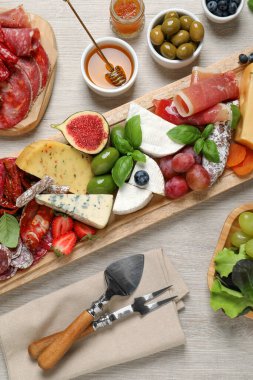 Beyaz ahşap masada servis edilen farklı lezzetli aperatifler.