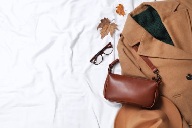 Beyaz kumaş üzerinde şık şapka ve sonbahar giysileri ile düz kompozisyon, metin için boşluk