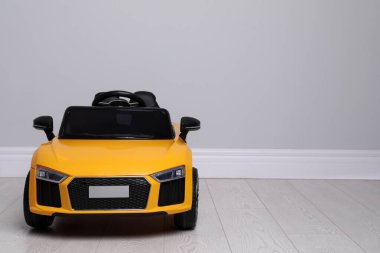 Çocukların elektrikli oyuncak arabası evin içinde, ışık duvarının yanında. Metin için boşluk