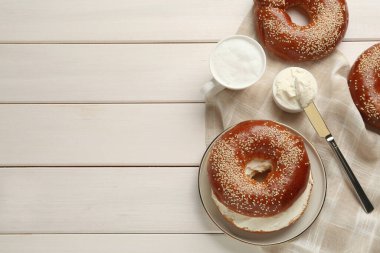 Krem peynirli leziz simit ve beyaz ahşap masada kahve, düz yatak. Metin için boşluk