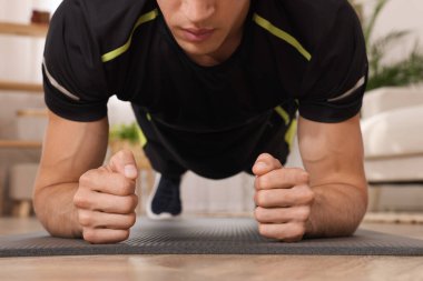 Evdeki zeminde tahta egzersizi yapan adam, yakın çekim.