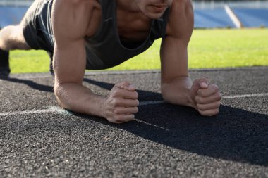 Spor adam stadyumda kalas egzersizi yapıyor, yakın plan.