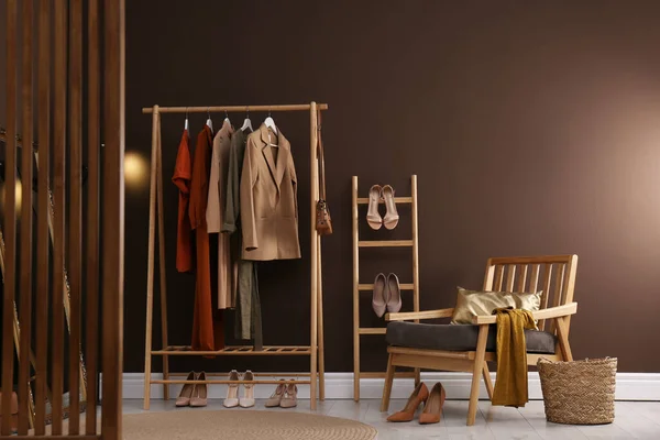 Modern dressing room interior with clothing rack and comfortable armchair