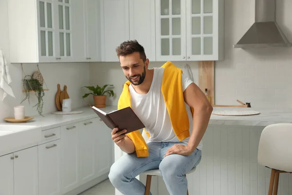 Όμορφος Άνθρωπος Ανάγνωση Βιβλίο Για Σκαμνί Στην Κουζίνα — Φωτογραφία Αρχείου