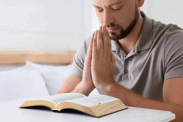 聖書を持つ宗教的な男がベッドルームで祈り — ストック写真