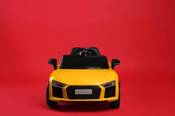 Kırmızı Arka Planda Çocuğun Elektrikli Oyuncak Arabası — Stok fotoğraf