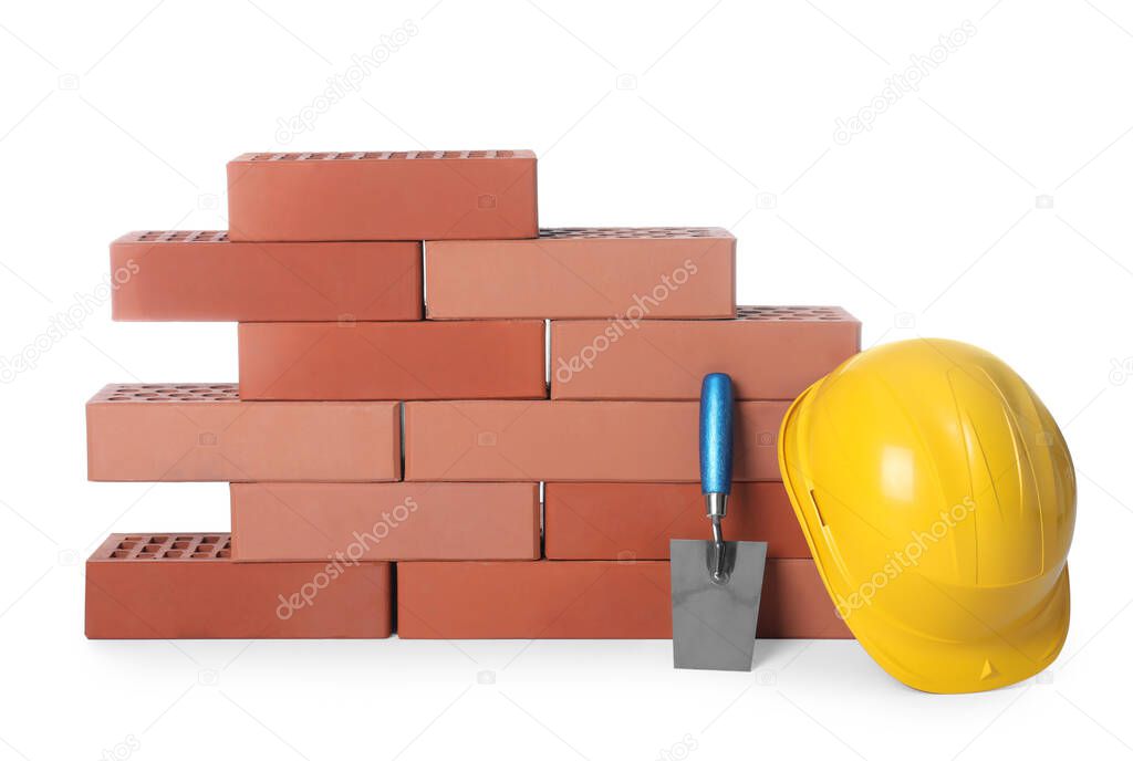 Many red bricks, hard hat and trowel on white background
