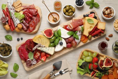 Beyaz ahşap masada servis edilen farklı lezzetli aperatifler.