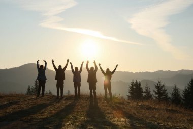 Bir grup insan dağlarda güneşin doğuşunun tadını çıkarıyor.