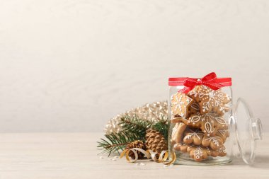 Cam kavanozda lezzetli Noel kurabiyeleri bej ahşap masada şenlikli dekorasyon, metin için yer