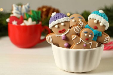 Beyaz ahşap masada, bulanık ışıklara karşı kâsede ev yapımı lezzetli Noel kurabiyeleri. Metin için boşluk