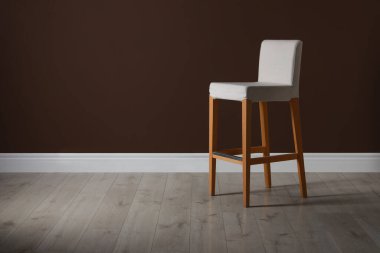 Kahverengi duvarın yanında şık bir bar taburesi. Metin için boşluk