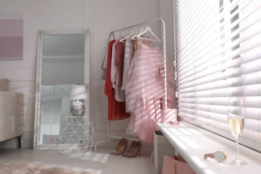 Giysi askısı ve aynası olan modern soyunma odası.