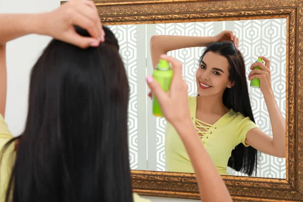 鏡の近くの彼女の髪に乾燥シャンプーを適用する女性 — ストック写真