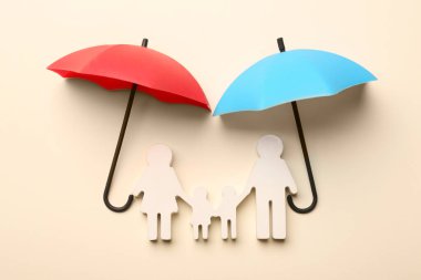 Bej arka planda mini şemsiyeler ve aile figürleri, düz yatış