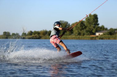 Genç çocuk nehirde wakeboard yapıyor. Aşırı su sporu