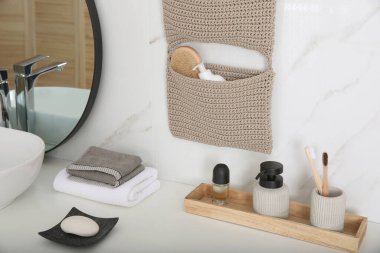 Banyoda duvarda örülü bir organizatör asılı.