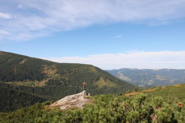 Dağlardaki kayalık zirvede sırt çantalı bir adam. Metin için boşluk