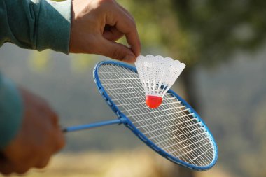 Güneşli bir günde dışarıda badminton oynayan adam, yakın plan.
