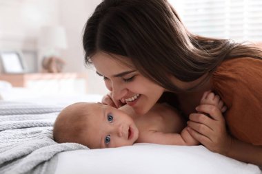 Anne evde tatlı bebeğiyle yatıyor.