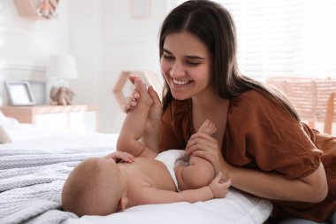 Anne evde tatlı bebeğiyle yatıyor.