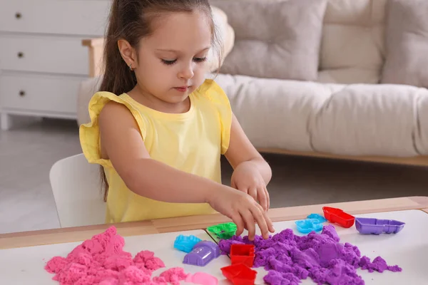 Милая Маленькая Девочка Играет Ярким Кинетическим Песком Столом Комнате — стоковое фото