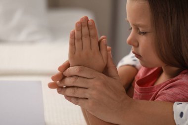 Küçük torunuyla birlikte evde dua eden olgun bir kadın.
