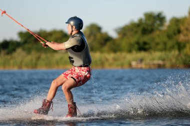 Genç çocuk nehirde wakeboard yapıyor. Aşırı su sporu