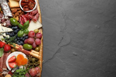 Siyah masada servis edilen farklı lezzetli aperatifler, üst manzara. Metin için boşluk