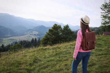 Dağ manzarasından hoşlanan bir kadın, arka manzara. Metin için boşluk