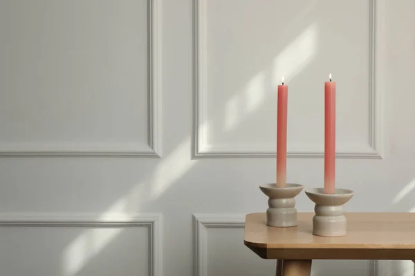 Halter Mit Brennenden Kerzen Auf Holztisch Neben Weißer Wand Drinnen — Stockfoto