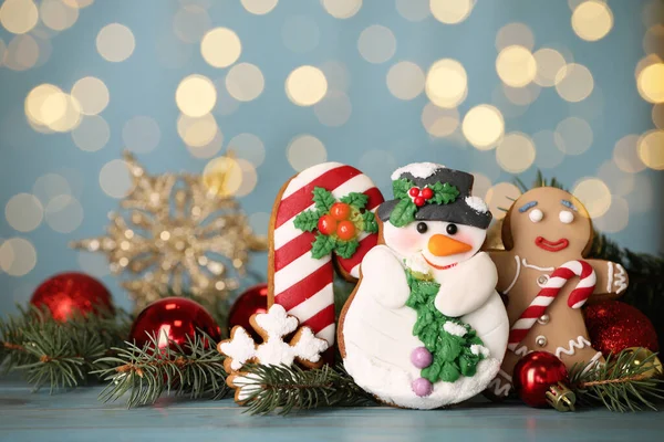 Süße Weihnachtsplätzchen Und Dekor Auf Hellblauem Tisch Gegen Verschwommenes Festlicht — Stockfoto