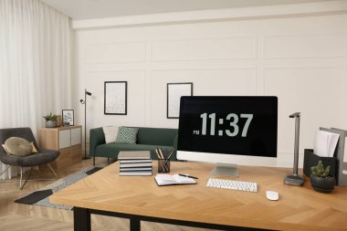 Odanın ahşap masasında modern bilgisayarla rahat bir iş yeri. İç tasarım