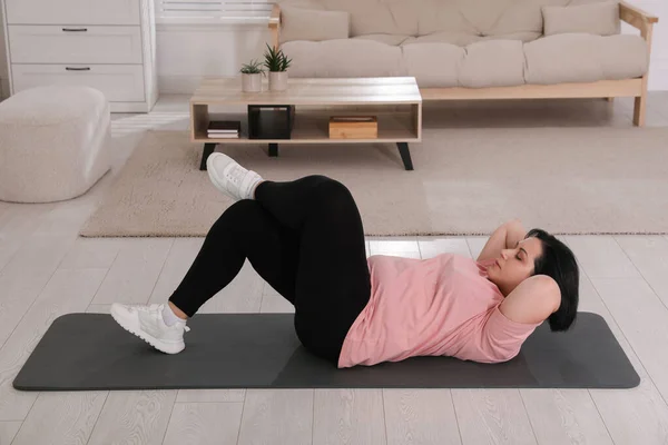 超重的成熟女人在家做腹肌运动 — 图库照片