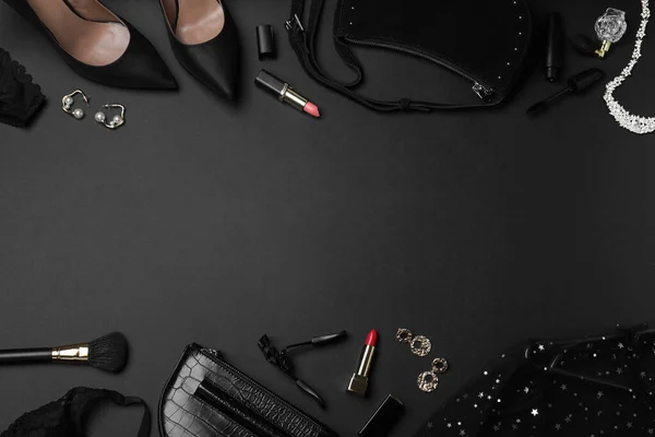 Women\'s clothes, makeup products and accessories on dark background, flat lay with space for text. Black Friday sale