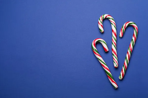 Muchos Dulces Bastones Caramelo Navidad Sobre Fondo Azul Puesta Plana — Foto de Stock