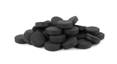 Beyaz arka planda aktif kömür hapları. Etkili sorbent