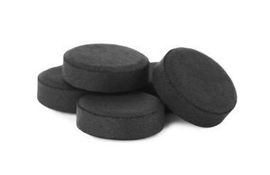 Beyaz arka planda aktif kömür hapları. Etkili sorbent