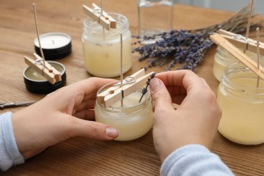 Ahşap masada aromatik mumlar yapan kadın, yakın plan.
