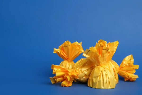 Cukierki Żółtych Opakowaniach Niebieskim Tle Miejsce Tekst — Zdjęcie stockowe