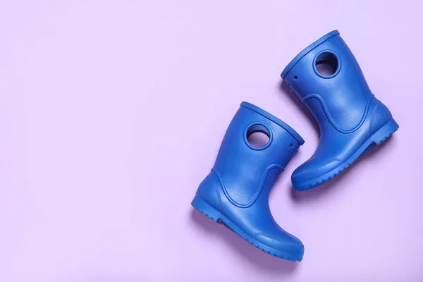 浅色背景的蓝色橡胶靴搭配 案文的篇幅 — 图库照片