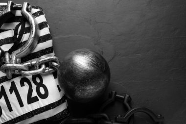Zincirli mahkum topu ve siyah masa üzerinde hapishane giysileri, düz yatıyordu. Metin için boşluk