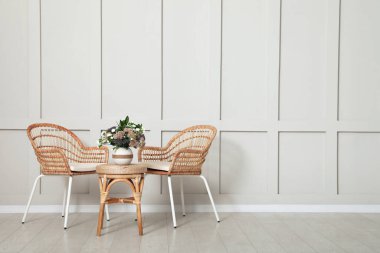 Hasır mobilyalar, güzel çiçekler ve boş duvarlarla dolu basit bir oda. Tasarım için boşluk