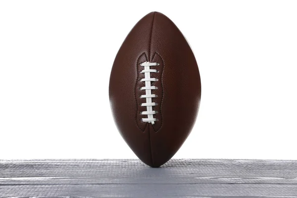 白い背景を持つ灰色の木製のテーブルの上にアメリカのサッカーボール — ストック写真