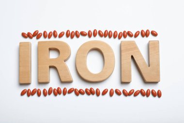 Demir kelime ve beyaz arka planda haplar, üst manzara. Anemi kavramı