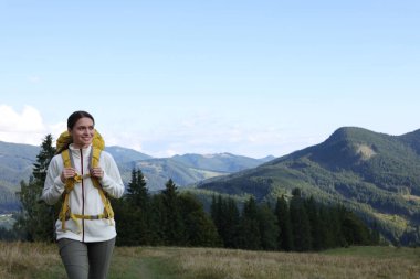 Sırt çantalı turist dağlarda yürüyor, yazı için yer var.