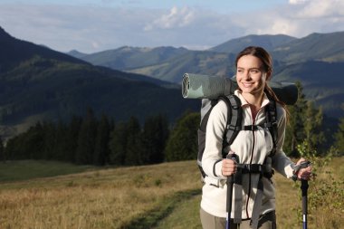 Sırt çantalı turist ve yürüyüş direkleri dağlarda yürüyüş yapıyor, yazı için yer var.