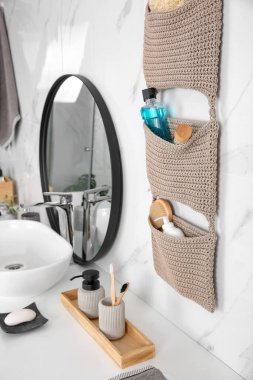 Banyoda duvarda örülü bir organizatör asılı.