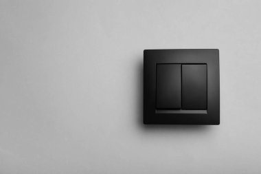 Gri arka planda modern plastik ışık anahtarı. Metin için boşluk