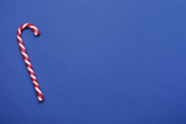 Mavi arka planda tatlı noel şekeri bastonu, üst manzara. Metin için boşluk